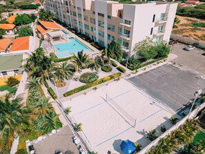 A hotel with a swimming pool, tennis court, and a parking area. - 2BR Condo w/ Pool-View Balcony near Palm Beach (Noord)