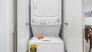 Een compacte, witte wasmachine met een bedieningspaneel, een doos Tide wasmiddel en een ENERGYGUIDE sticker.