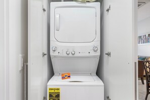 A compact, white washing machine with a control panel, a Tide detergent box, and an ENERGYGUIDE sticker. - Prime Location! Beach near 2BR Condo w/ Pool View (Noord)