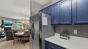 Una cucina moderna con frigorifero integrato, un tostapane e mobili azzurri.