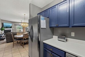 A modern kitchen with a built-in refrigerator, a toaster, and blue cabinets. - 3 BR/3 BA Recently Updated Pigeon Forge Condo - Walk to Pkwy - Free Tickets (Pigeon Forge)