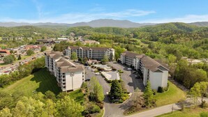 Un hotel su più piani con un parcheggio e vista sulle colline circostanti.