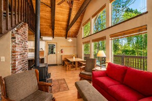 Un intérieur chaleureux avec une cheminée, des meubles en bois et de grandes fenêtres.