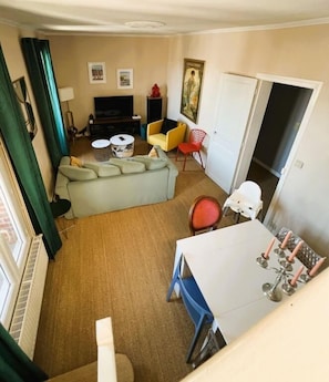 A living room with a sofa, a TV, a dining table, and a chair. - Marceau" duplex apartment in the seaside district (Mers-les-Bains)