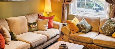 A living room with two sofas, a coffee table, and a lamp.