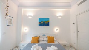 A bedroom with a bed, two nightstands, a painting, and a door. - House Murice- Amalfi (Amalfi)