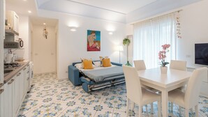 A modern room with a bed, a dining table, and a kitchen area. - House Murice- Amalfi (Amalfi)