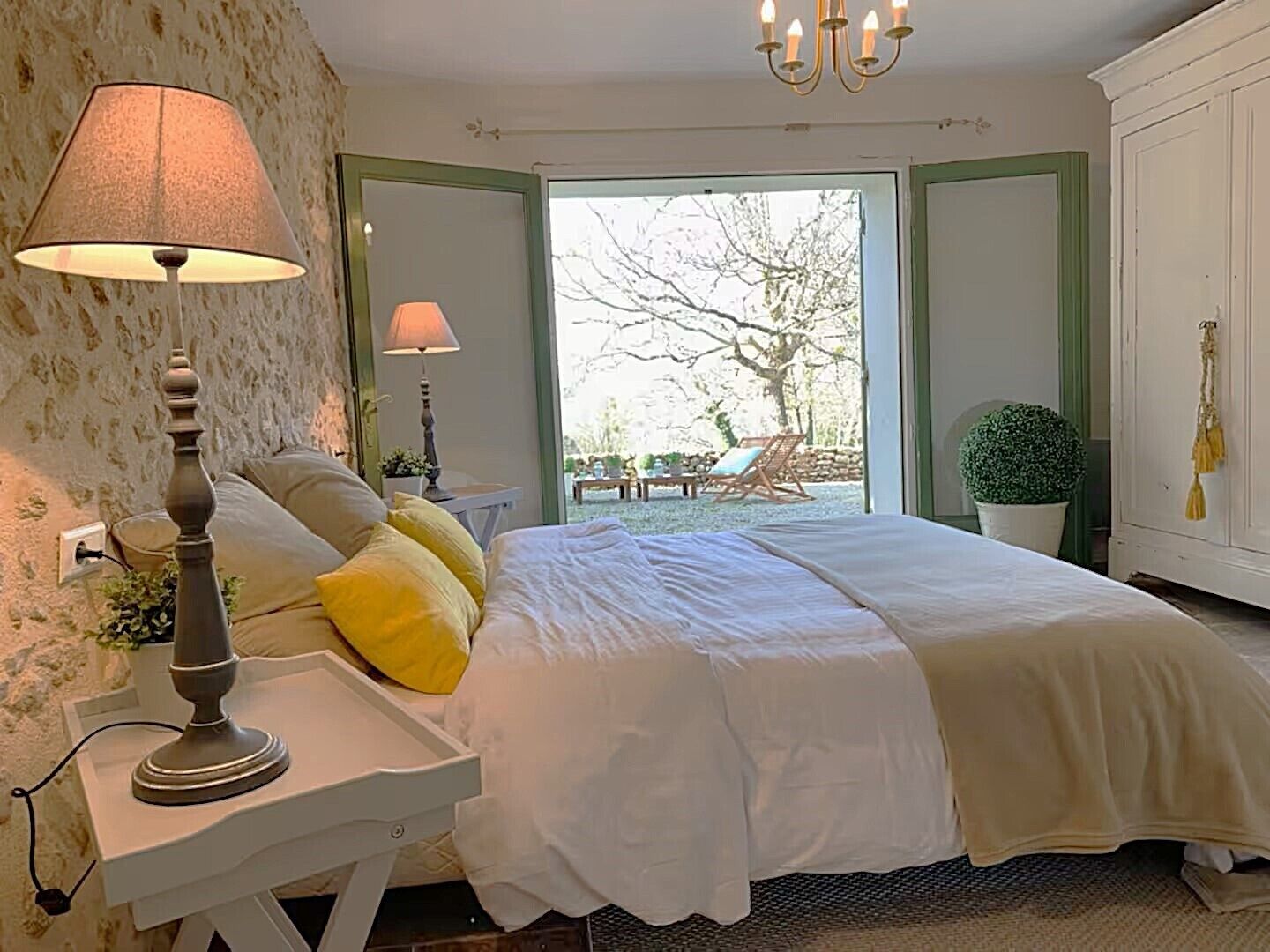 Une chambre à coucher avec un lit, une lampe de chevet, une fenêtre et une vue sur l’extérieur.