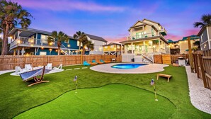 Zona residenziale con piscina, prato verde e recinzione in legno.