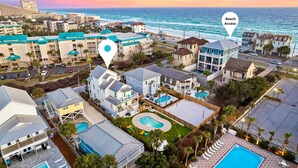 Un hotel sulla costa con diversi edifici, piscina e accesso diretto alla spiaggia.