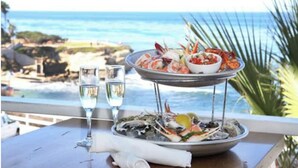 A seafood platter on a table with a view of the ocean.