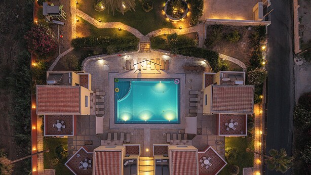 An aerial view of a resort with a central swimming pool, multiple lounge areas, and landscaped gardens. - Villa Portokalea, 200m From The Beach, Heated Pool (CHANIA)
