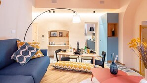 Een moderne woonkamer met een bank, eettafel en keukenhoek.