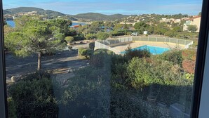 A pool surrounded by greenery and a view of a coastal town. - Agay 4p, Piscine, Vue Mer, Tout a Pied (Saint-Raphaël)