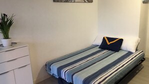 A bedroom with a bed, a dresser, a potted plant, and a painting on the wall. - Agay 4p, Piscine, Vue Mer, Tout a Pied (Saint-Raphaël)