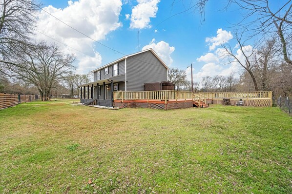 A two-story house with a covered porch and a fenced deck.