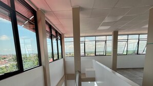 A spacious interior with a staircase, large windows, and a view of the outside. - YURIMAGUAS APARTMENTS (Yurimaguas)