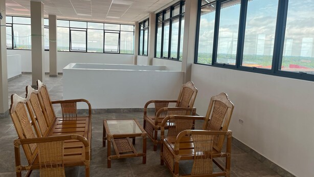 A spacious room with large windows, wicker furniture, and a tiled floor. - YURIMAGUAS APARTMENTS (Yurimaguas)