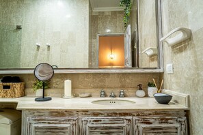 A bathroom with a large mirror, a sink, and a vanity area. - Ayos - 1BDR Apto céntrico Edificio Ayos (Cartagena)