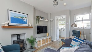 A modern living room with a fireplace, a television, and a sofa. - Charming 2-Bedroom House in Portaferry – Perfect for a Cosy Getaway (Portaferry)