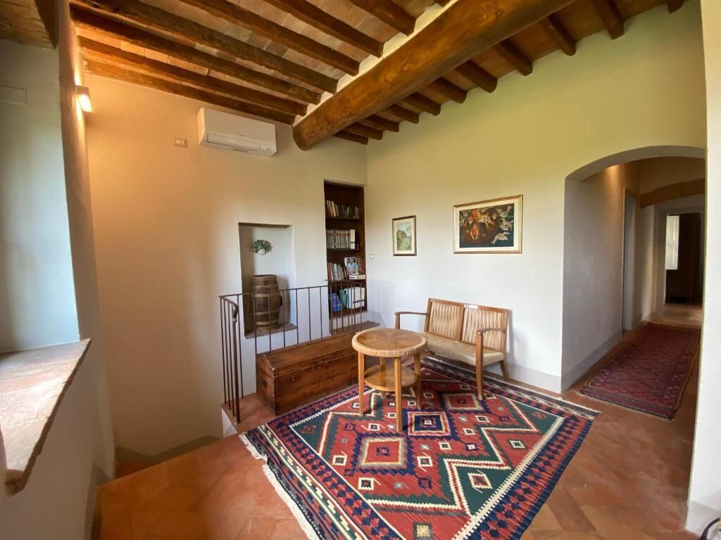 A cozy interior with a wooden bench, a round table, and a patterned rug.