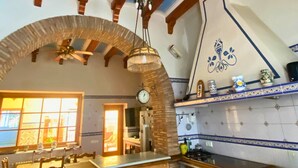 A kitchen with wooden beams, a brick arch, and a tiled backsplash. - Room-orange Room Your Refuge of Tranqu (Alzira)