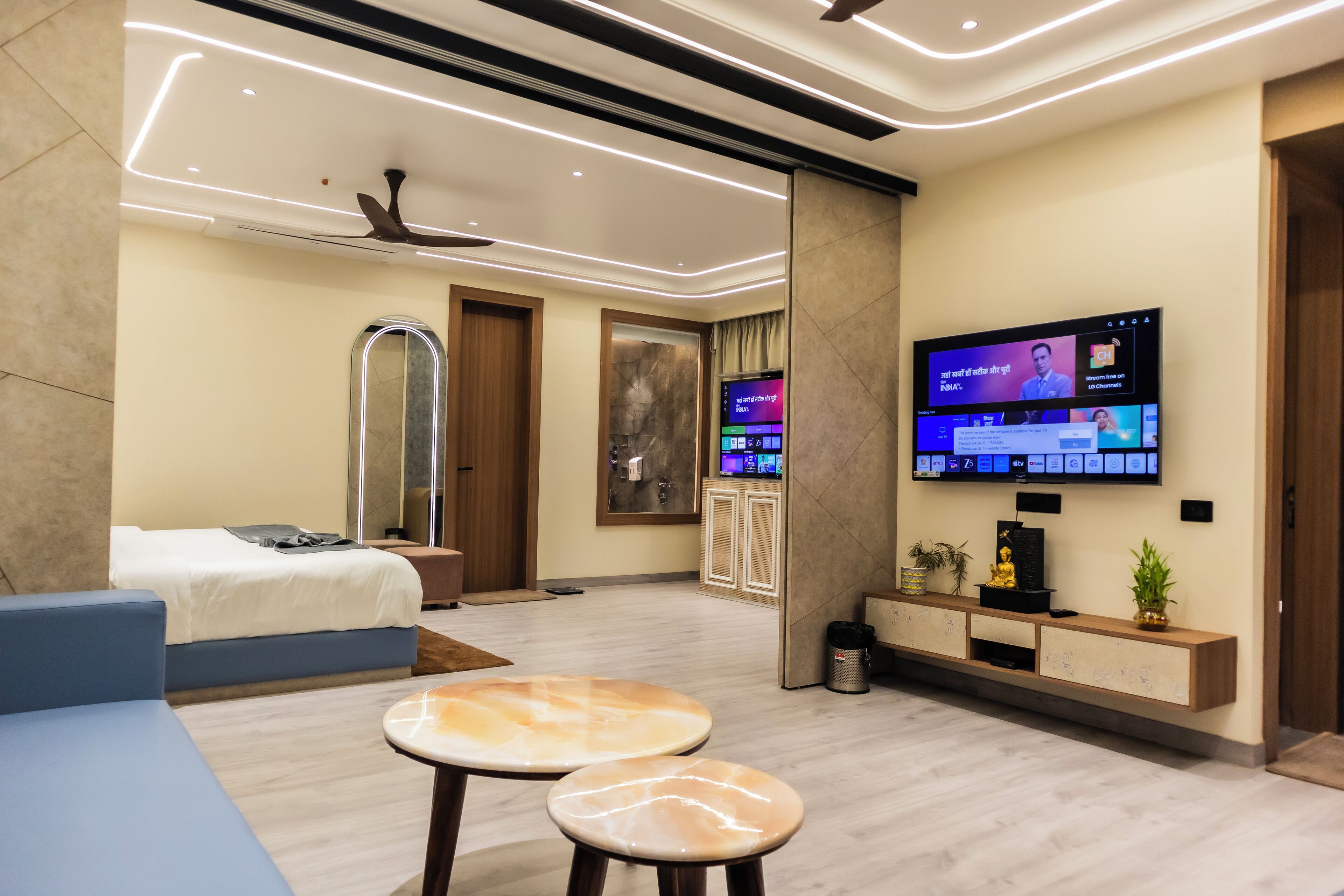 Una camera d'albergo moderna con un letto, un divano, una TV e un tavolino.