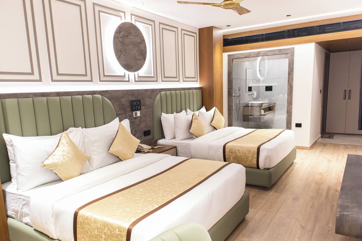 Ein Hotelzimmer mit zwei Betten, einem Badezimmer und einer Sitzecke.