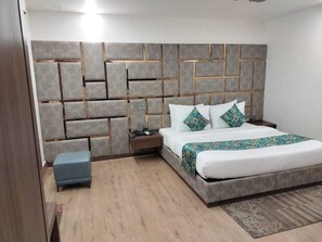 Un dormitorio moderno con una cama grande, una mesita de noche y un pequeño banco.