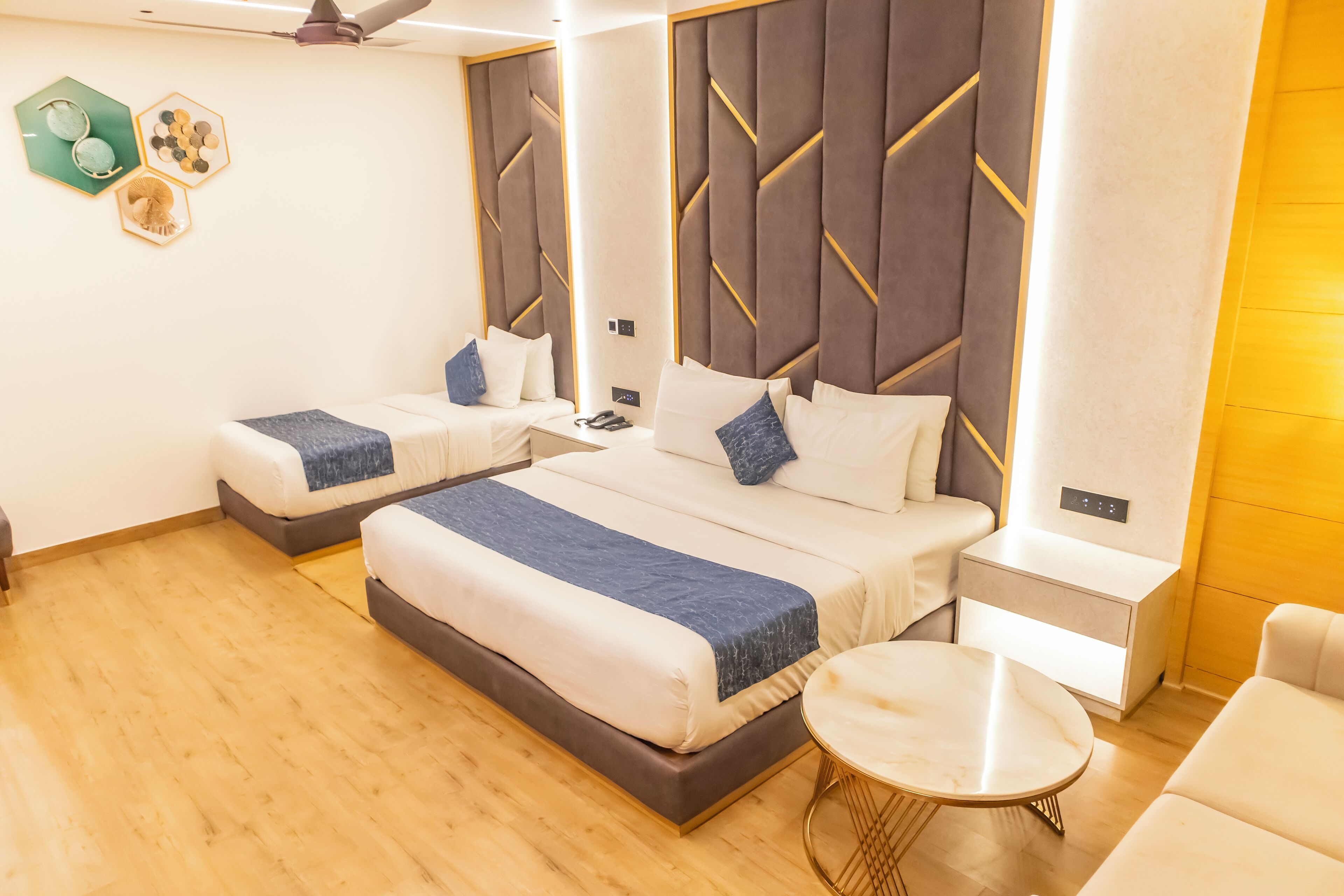 Una habitación de hotel con dos camas, una mesita redonda pequeña y una mesita de noche.