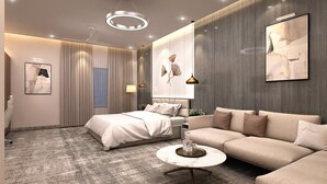 Moderni hotellihuone, jossa on suuri sänky, sohva, marmorinen sohvapöytä ja taideteoksia seinillä.