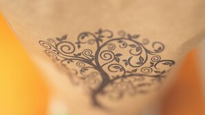 A close-up of a paper bag with a tree design. - Greenwood Edge Kandy (Kandy)