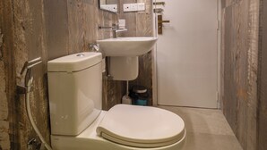 A bathroom with a toilet, sink, and mirror. - Greenwood Edge Kandy (Kandy)