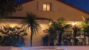 Een gebouw met een zwembadgedeelte, inclusief een jacuzzi en een waterattractie met verlichting.
