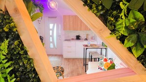 Een kamer met een spiegel met houten lijst, die een moderne keuken en woonruimte weerspiegelt.