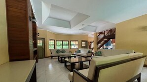 A spacious living area with a sofa set, a coffee table, and a dining table.