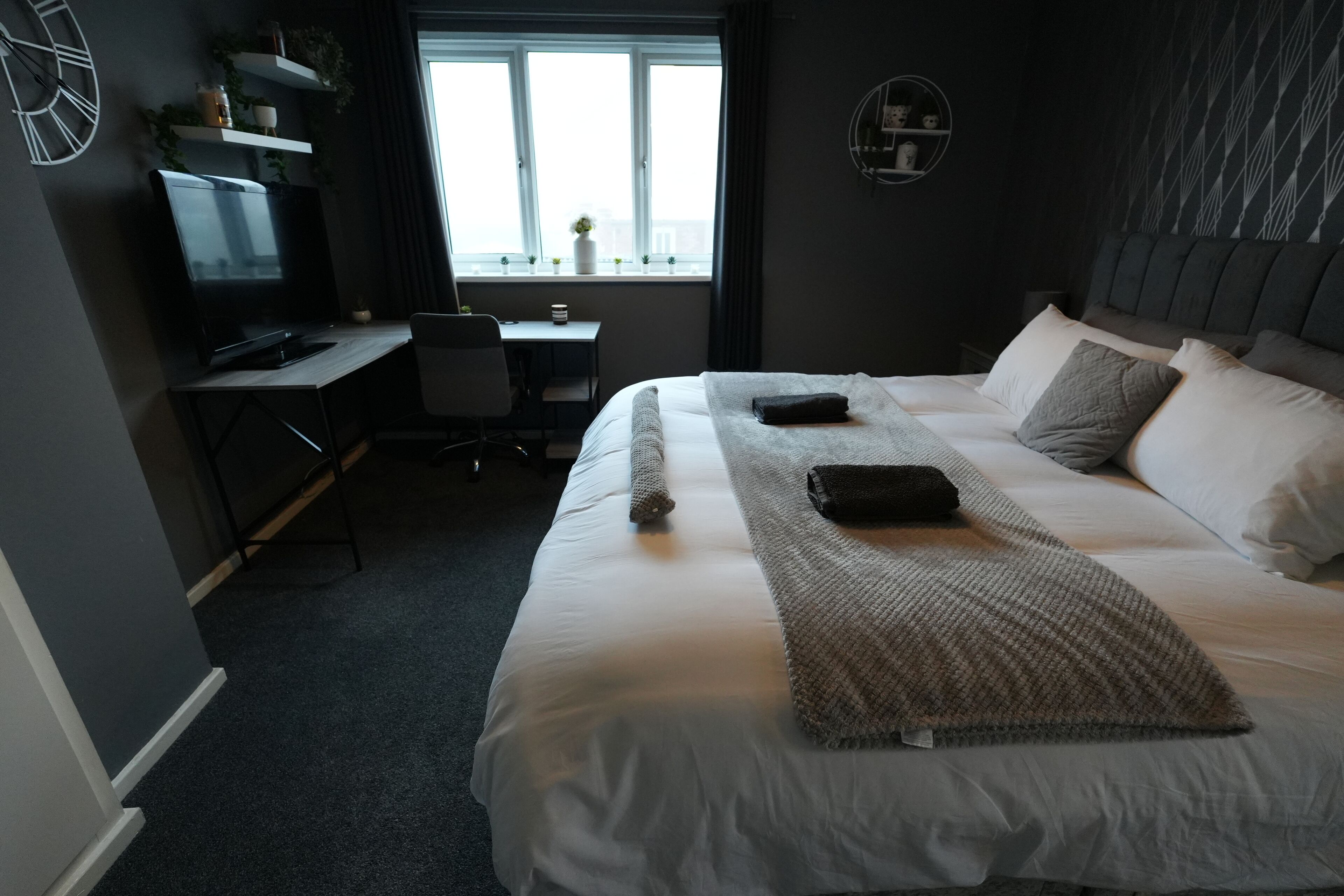 Une chambre d’hôtel avec un grand lit, un bureau et une fenêtre donnant sur un beau paysage.