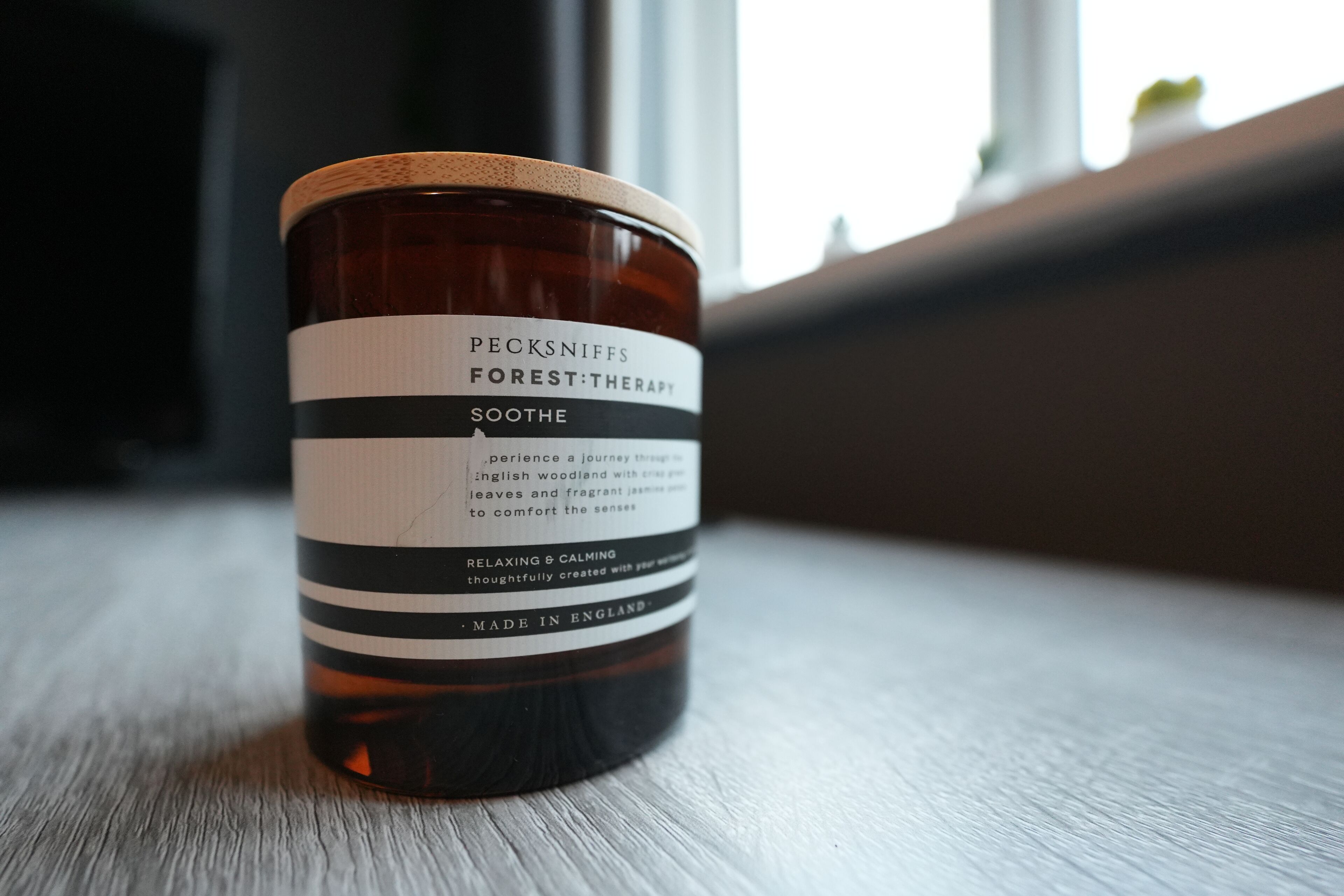 Un tarro de Pecksniffs Forest Therapy Soothe sobre una superficie de madera.