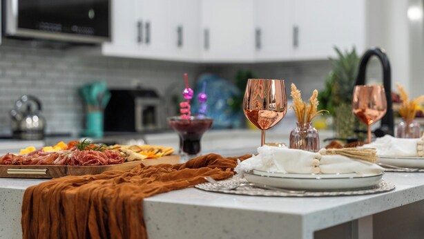 A modern kitchen with a dining area set up for a meal.