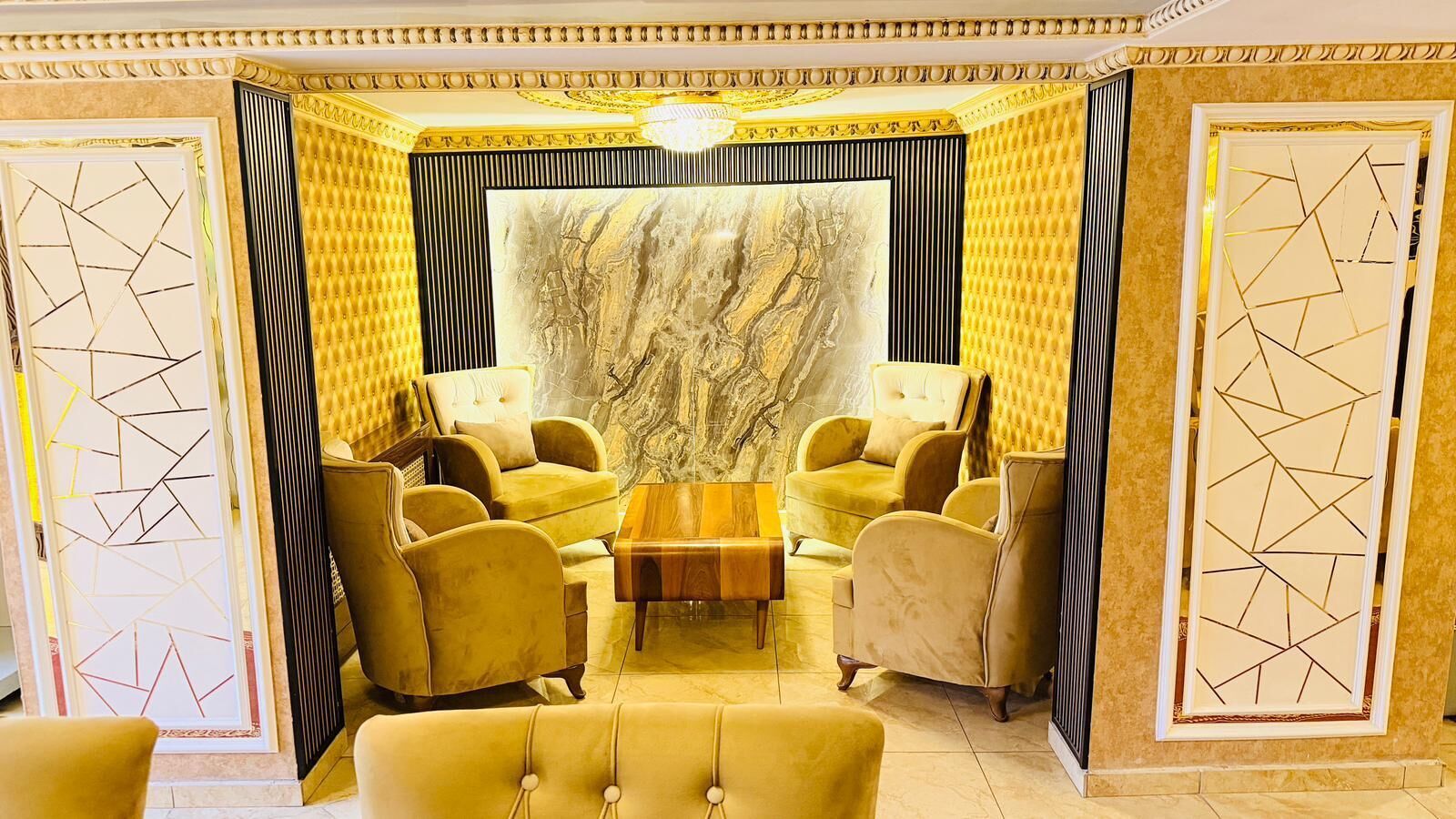 A room with a central coffee table, four armchairs, and a sofa.