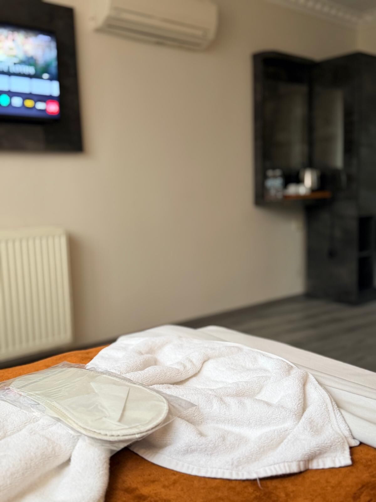 Una habitación de hotel con una cama, un televisor en la pared y una chimenea.