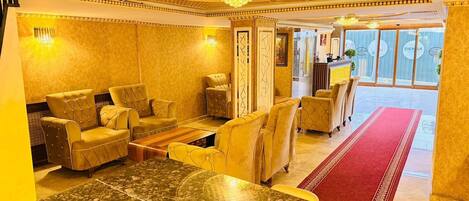 A luxurious lobby with plush seating, a reception desk, and a view of the outdoor area.
