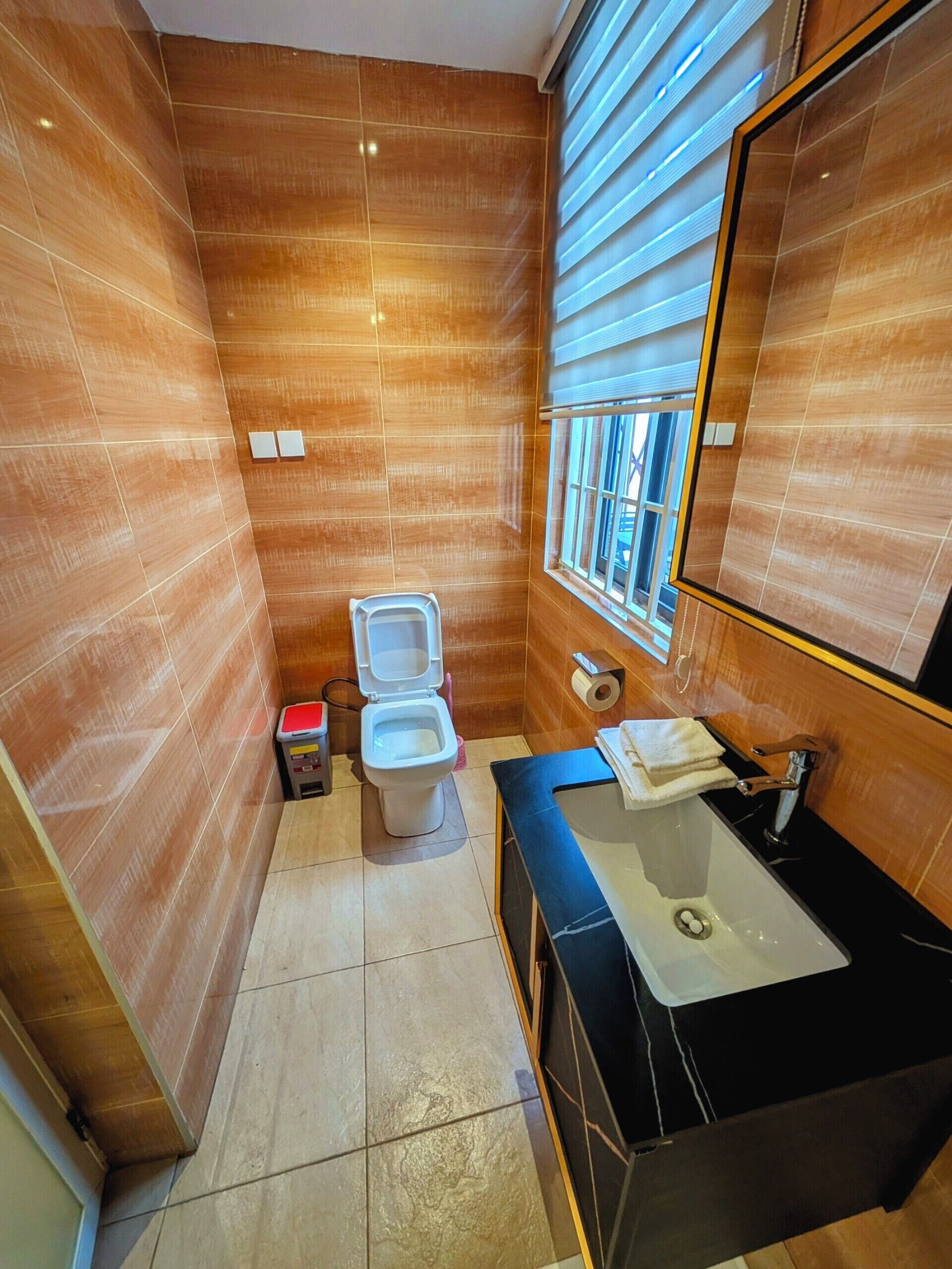 Ein Badezimmer mit Toilette, Waschbecken und Fenster.