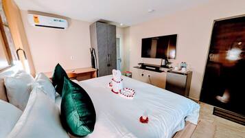 Une chambre d’hôtel équipée d’un lit, d’oreillers, d’un bureau, d’une télévision et d’un appareil de climatisation.