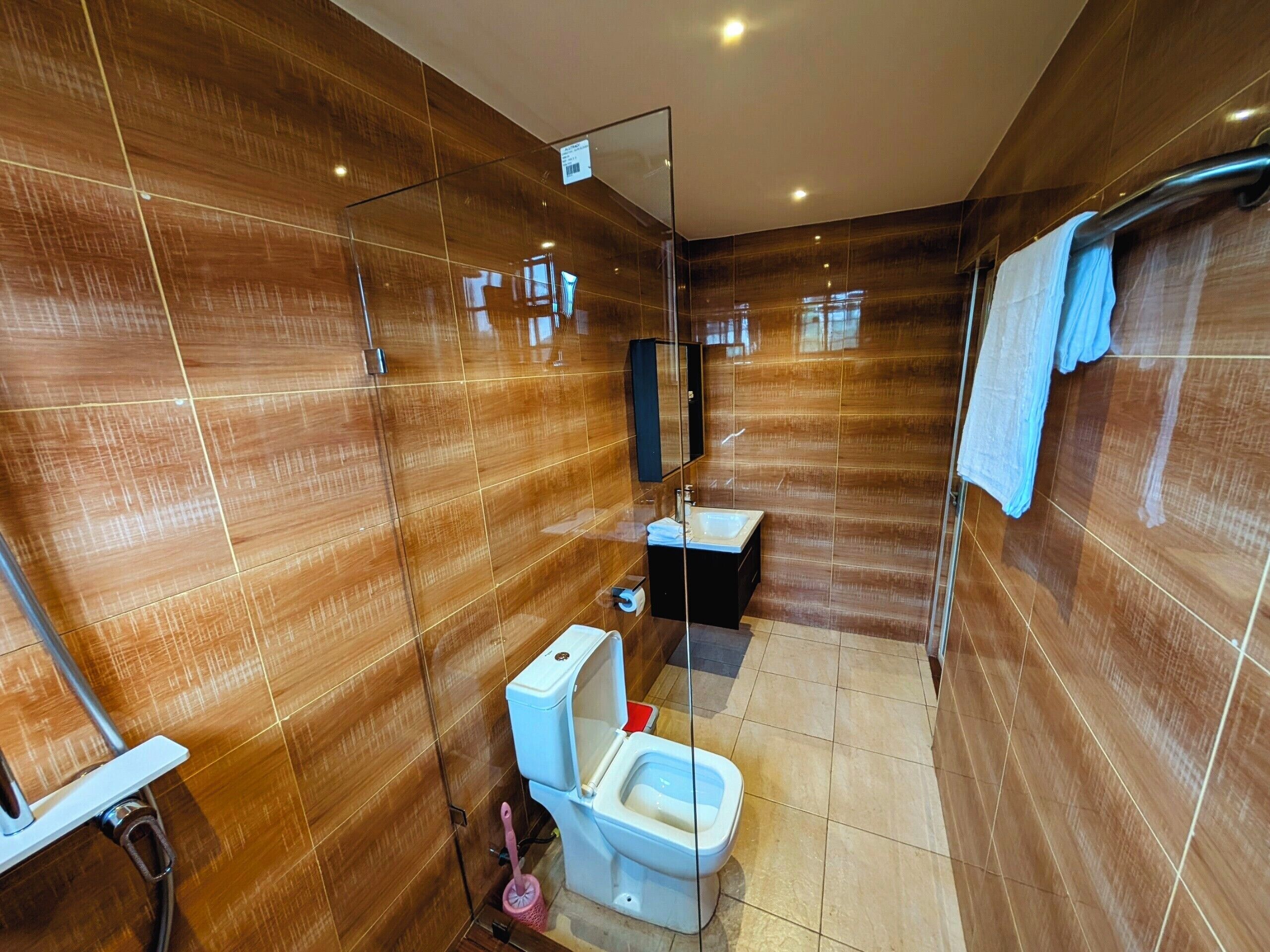 Un bagno moderno con box doccia in vetro, un water e un lavandino.