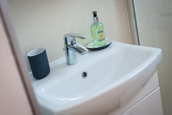 A white bathroom sink with a chrome faucet and a bottle of Cien handwash on the edge. - The Westfield, comfortable 2 bedroom apartment that sleeps 4 (Edinburgh)