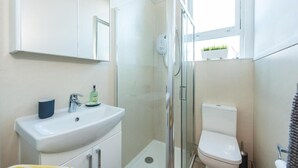 A modern bathroom with a glass-enclosed shower, a white sink, and a toilet. - The Westfield, comfortable 2 bedroom apartment that sleeps 4 (Edinburgh)