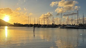 Un puerto deportivo con varios veleros amarrados al atardecer.