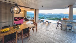 Eine großzügige Terrasse mit Esstisch, Stühlen und Blick auf die Landschaft.