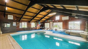 An indoor swimming pool with a tiled floor, surrounded by lounge chairs and a hot tub. - Linney Cottage - UK48986 (Looe)